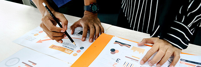 Hands reviewing charts and data